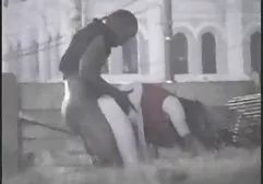 A pretty woman with a smile on her face, naked, is walking along crowded streets.